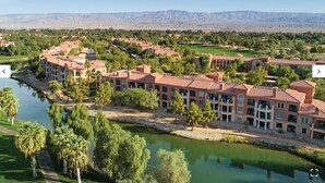 A resort with multiple buildings, a river, and a mountainous backdrop.