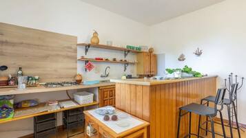 A compact kitchen with wooden cabinets, a central island, and bar stools.