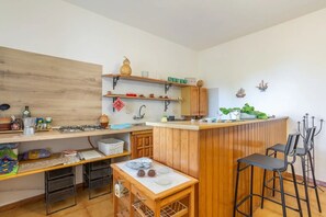 Eine kompakte Küche mit Holzschränken, einer zentralen Kochinsel und Barhocker.