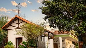 Una casa a due piani con tetto in tegole, un portone d'ingresso e un piccolo portico.
