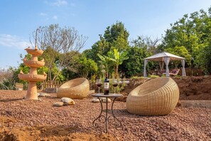 A garden with a stone fountain, wicker furniture, and a gazebo. - Charming Farmhouse Retreat in Santa Ursula, Tenerife (Santa Ursula)