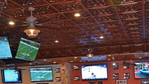A restaurant with multiple TVs on the wall, wooden tables and chairs, and a ceiling with a decorative pattern. - DEC 27-Jan 3   89 per ngt.  COZY KING STUDIO! Enjoy Christmas Shows  in Branson (Branson)