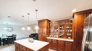 Una cocina moderna con armarios de madera, una isla central y un refrigerador empotrado.