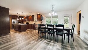 Una cocina moderna con armarios de madera, una isla central e iluminación colgante.
