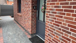 A brick exterior with a dark door, a small window, and a mailbox.