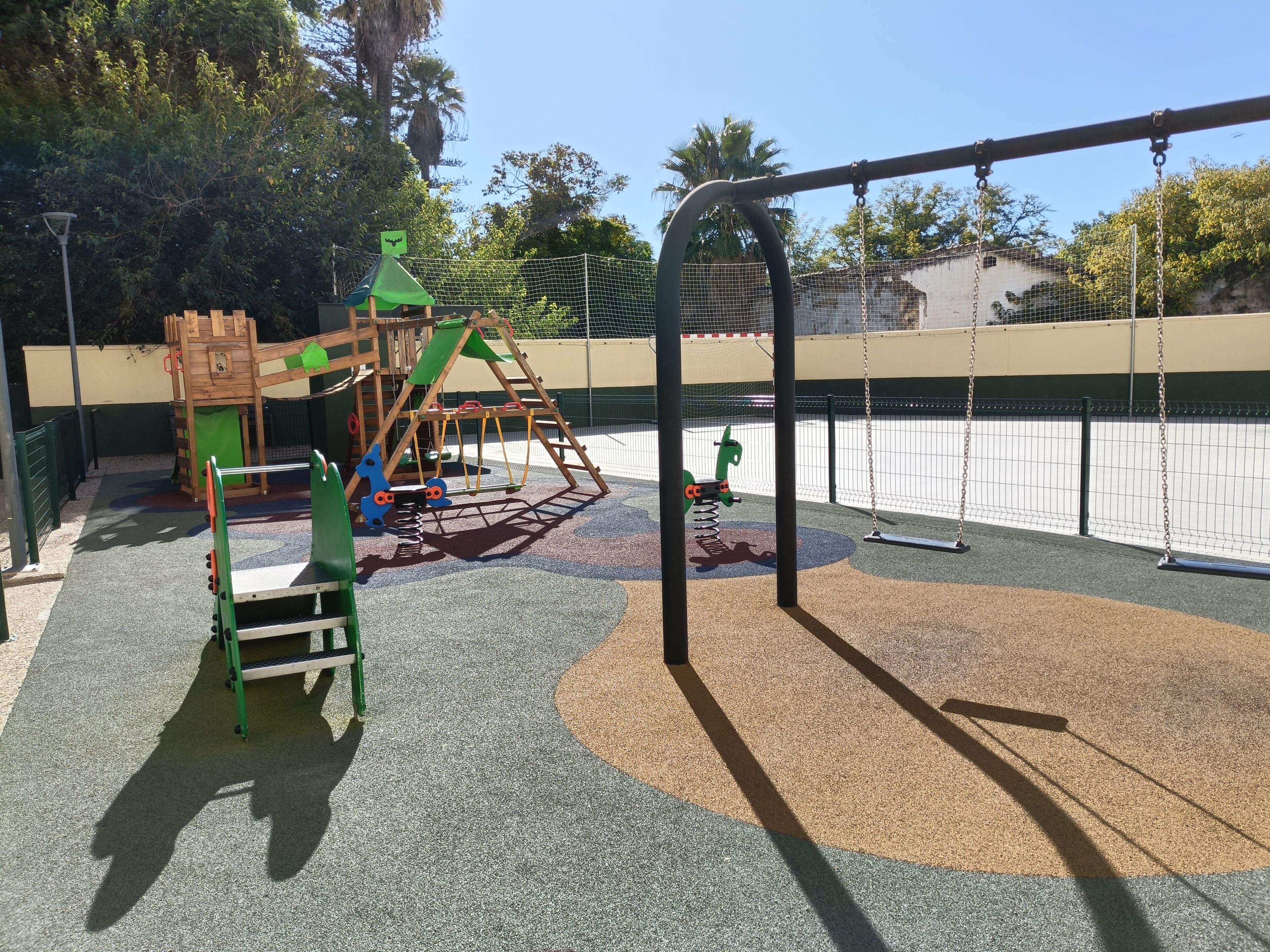 A playground with a swing set, climbing structures, and a slide.