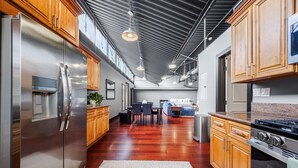 Una cocina moderna con electrodomésticos de acero inoxidable, armarios de madera y un comedor con mesa y sillas.