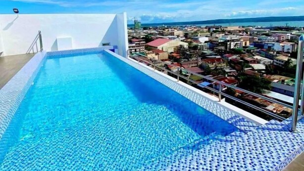 Une piscine sur le toit offrant une vue dégagée sur le paysage urbain en arrière-plan.