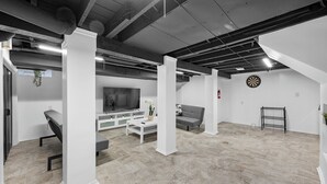 Ein modernes Wohnzimmer mit Flachbildfernseher, grauem Sofa und Couchtisch.