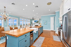 A spacious kitchen with a large island, wooden flooring, and a view to the outside. - Beachfront | 4BR | Sleeps 14 | Pet-Friendly | NEW Hot Tub (Galveston)