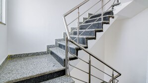 A staircase with granite steps and metal handrails, leading to an upper floor. - Hotel Casa Inn (Baruipur)