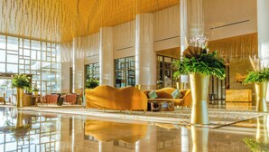 A spacious lobby with a reflective floor, modern furniture, and a unique ceiling design with hanging elements. - Luxury Oceanview Retreat in Cancun 🌊 (Cancún)