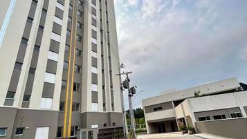 Un estacionamiento de varios pisos con plazas reservadas para personas con discapacidad, un edificio alto de diseño moderno y un cielo despejado.