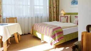 A bedroom with a bed, a table, and a chair. - Fackler Apartments 1 Riederstein - Relaxed Bavarian Living Near Lake Tegernsee (Tegernsee)