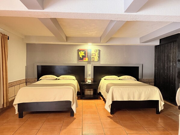 A hotel room with two beds, a nightstand, a wall-mounted lamp, and a dark wardrobe. - Hotel Mirage Express (Matamoros)