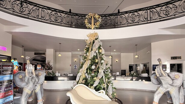 A lobby with a Christmas tree, a reception desk, and two elephant statues. - Hotel Mirage Express (Matamoros)