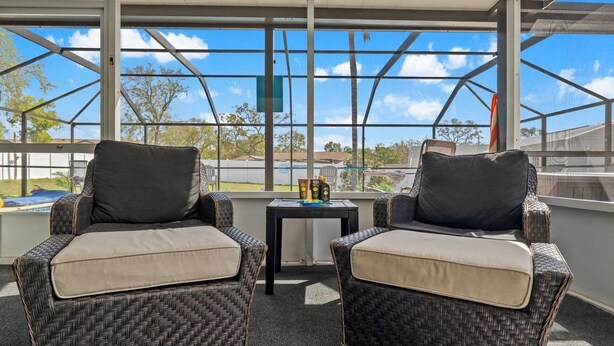 A covered outdoor seating area with wicker chairs and a small table. - The Getaway (Spring Hill)