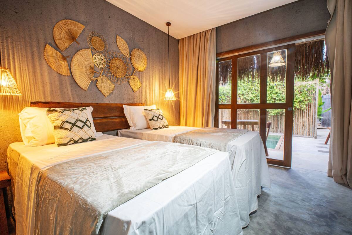 Une chambre d’hôtel avec deux lits, une grande fenêtre et une vue sur l’extérieur.