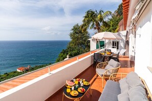 A balcony with a table set for breakfast, overlooking the sea. - Mediterranean Style • Sound of Waves • Sunsets (Arco da Calheta)