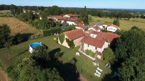 A residential area with houses, a swimming pool, and a grassy field.