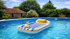 A swimming pool with a blue and white inflatable lounge chair and a yellow cushion.
