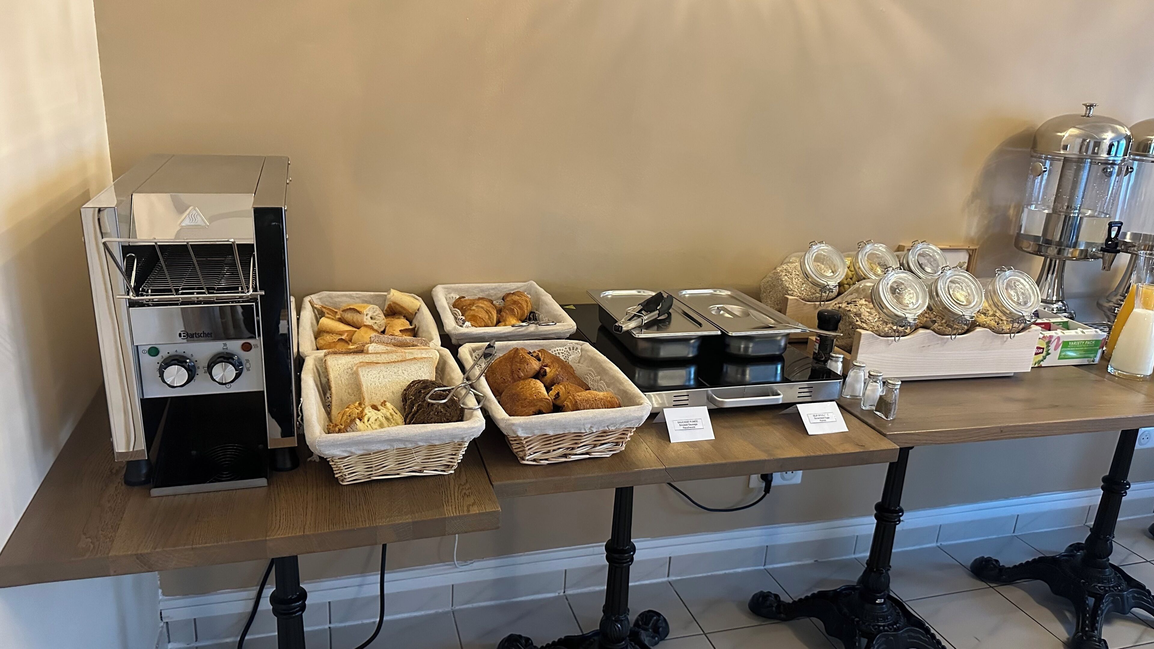 Una barra de desayuno con diversas opciones de comida y una máquina de café.