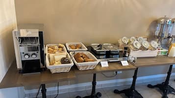 Una barra de desayuno con diversas opciones de comida y una máquina de café.