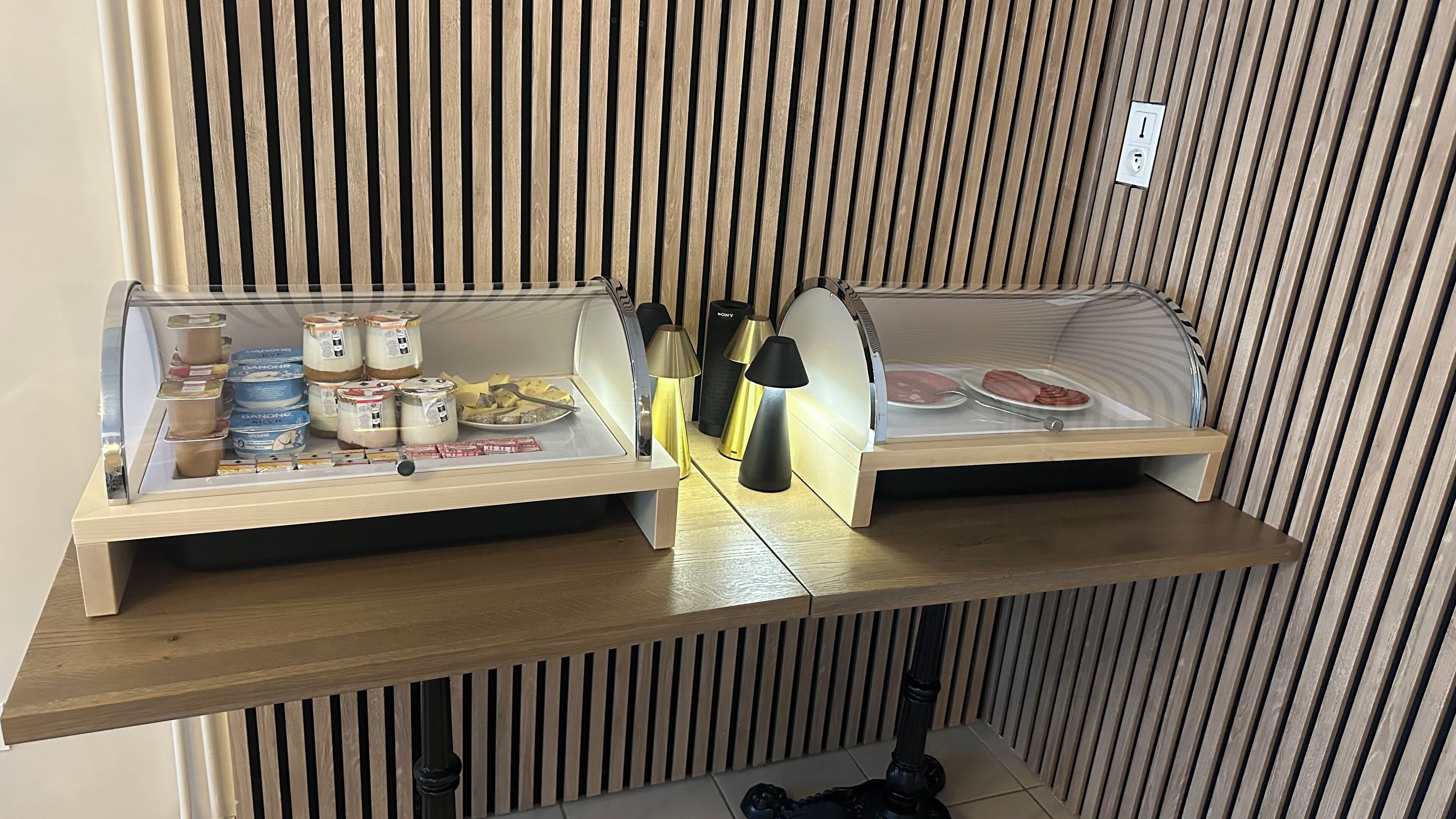 Un expositor de madera con alimentos y una lámpara.
