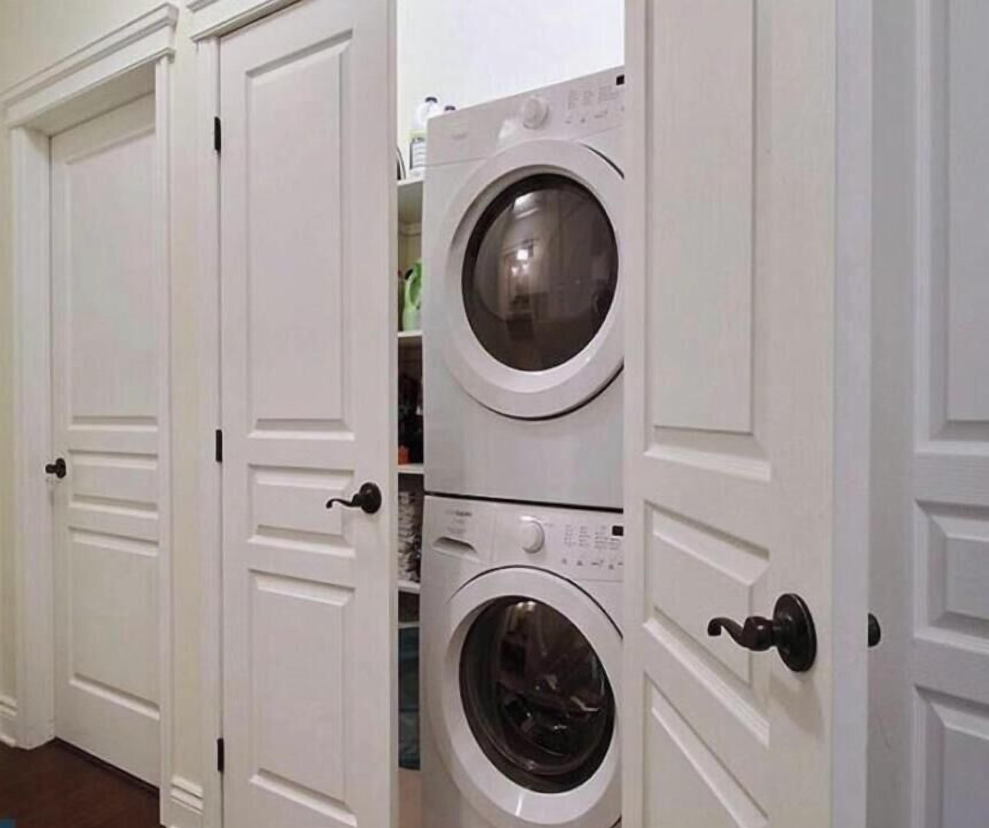 A laundry room with two stacked front-loading washing machines and a dryer.