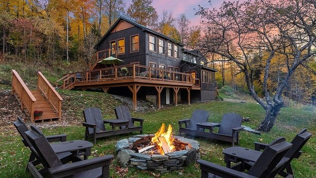 Une cabane dotée d’une terrasse, d’un espace salon extérieur et d’un foyer.