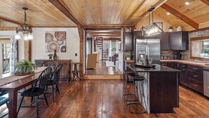 Une cuisine spacieuse dotée de planchers en bois, d’un îlot central et d’appareils électroménagers modernes.