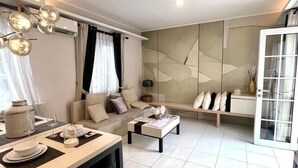 Ein modernes Wohnzimmer mit Sofa, Couchtisch und Essbereich.