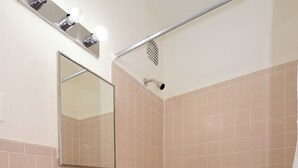 Une salle de bain avec un lavabo, un miroir et une baignoire.