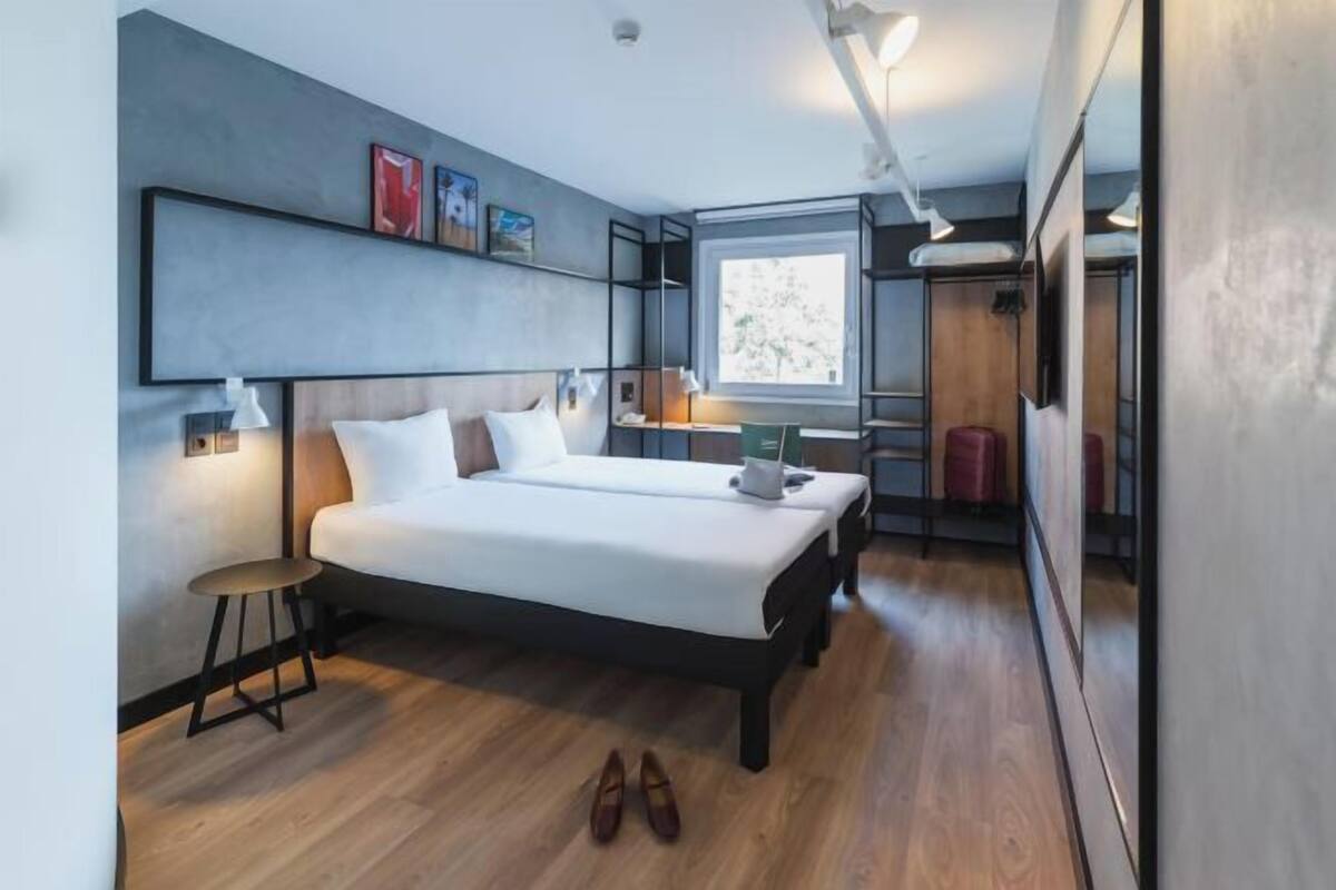 Ein modernes Schlafzimmer mit einem großen Bett, Nachttischen und einem Fenster.