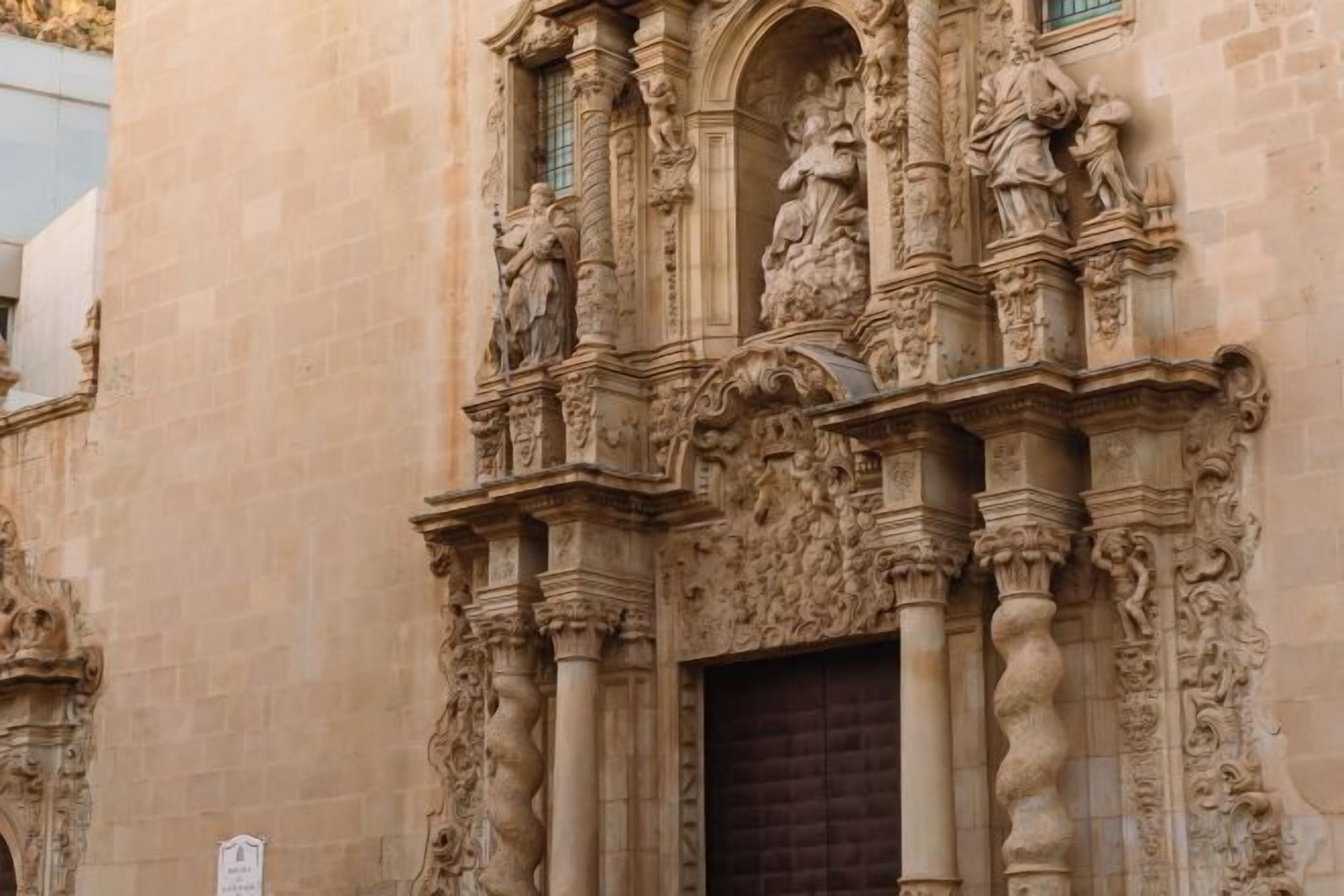 A building facade with intricate stone carvings and a large wooden door.