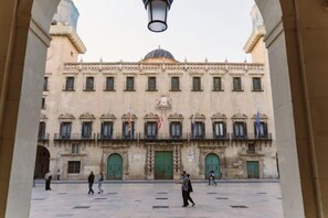 Un edificio histórico con una cúpula central, múltiples ventanas y banderas.