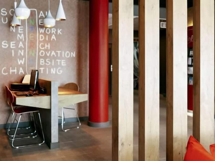 A modern workspace with a desk, chair, and a wall with words related to digital work.