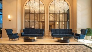 Un hall d’entrée avec deux canapés, une table basse et un lustre.