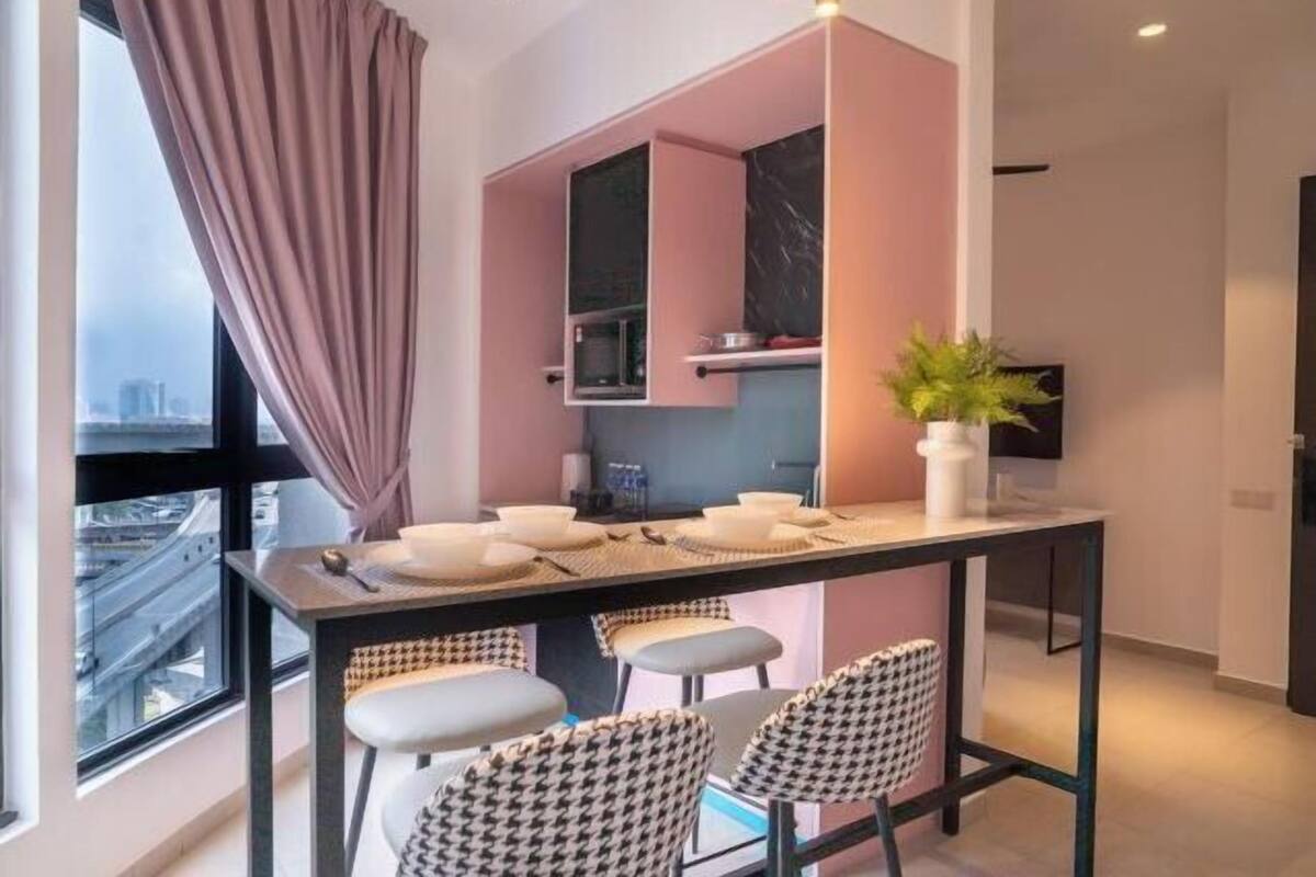 Une cuisine moderne avec un plan de travail noir, un four à micro-ondes et une plante posée sur le plan de travail.