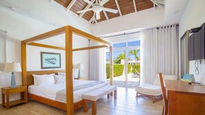 Ein Schlafzimmer mit Himmelbett, Schreibtisch, Stuhl und Blick ins Freie.