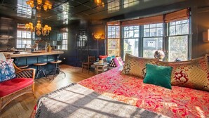 Une chambre confortable avec un grand lit, un coin repas et un bar.