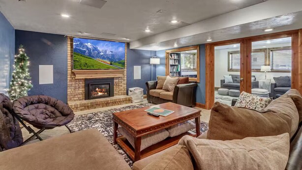 Una sala de estar acogedora con chimenea, televisor grande y asientos cómodos.
