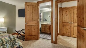 Una habitación con una cama, un escritorio y un armario de madera.