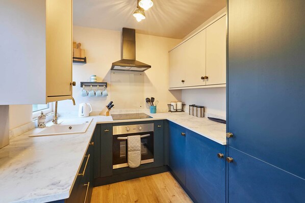 A modern kitchen with a built-in oven, a sink, and a stove. - Host Stay Daisy Cottage (Ripon)