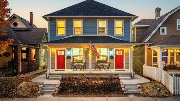 A two-story house with a porch, a flag, and a small garden. - 3 Mi to Dtwn Indy: Urban Retreat w/ Outdoor Space (Indianapolis)