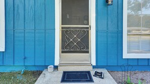 A blue house with a white door, a black doormat, and a small black object on the ground. - Paddle, Hike & More: Quiet Home in High Springs! (High Springs)