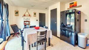 A compact kitchen with a refrigerator, dining table, chairs, and a coffee shelf. - Paddle, Hike & More: Quiet Home in High Springs! (High Springs)