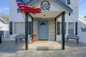 A cottage with a stone facade, a blue door, and a sign above the entrance.