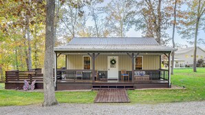 A rustic cabin with a porch, wooden deck, and a front door with a wreath. - Walk to Marina & Beach: Charming Home in Hardin (Hardin)