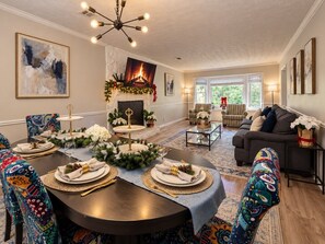 A dining area with a fireplace, a sofa, and a coffee table. - Soaking Tub| Fenced Yard|Screened Patio| Near Golf (Tucker)
